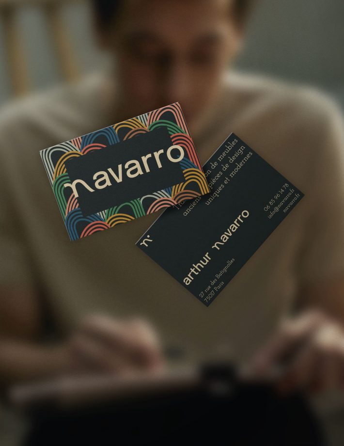 Mockup de carte de visite de Navarro qui flotte dans les airs, avec un jeune artisan en fond.